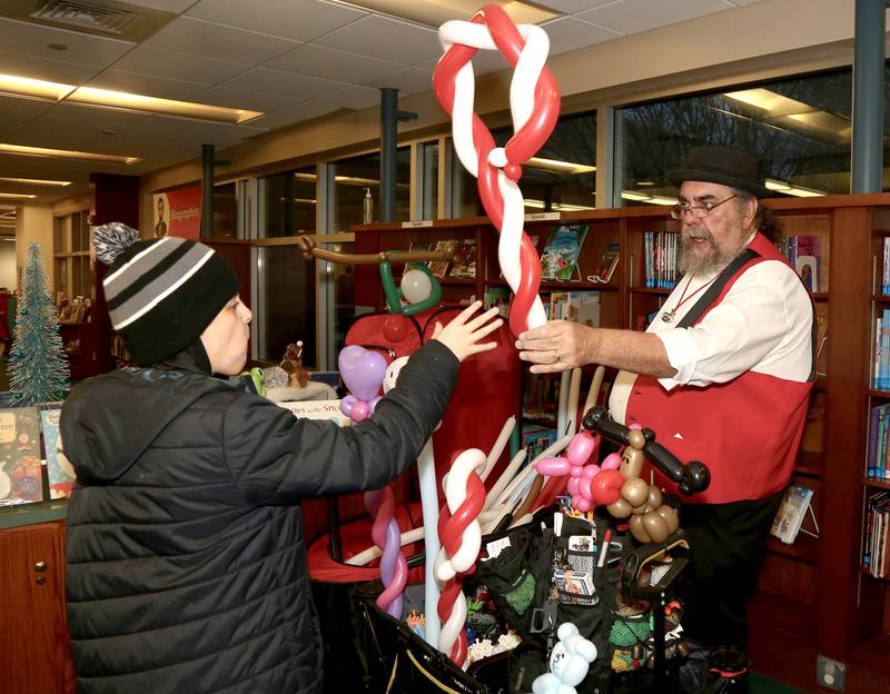 Chase Unterman of Elburn receives a candy cane balloon made by Magic Matt at the 2023 Elburn Christmas Stroll on Saturday, Dec. 2, 2023.