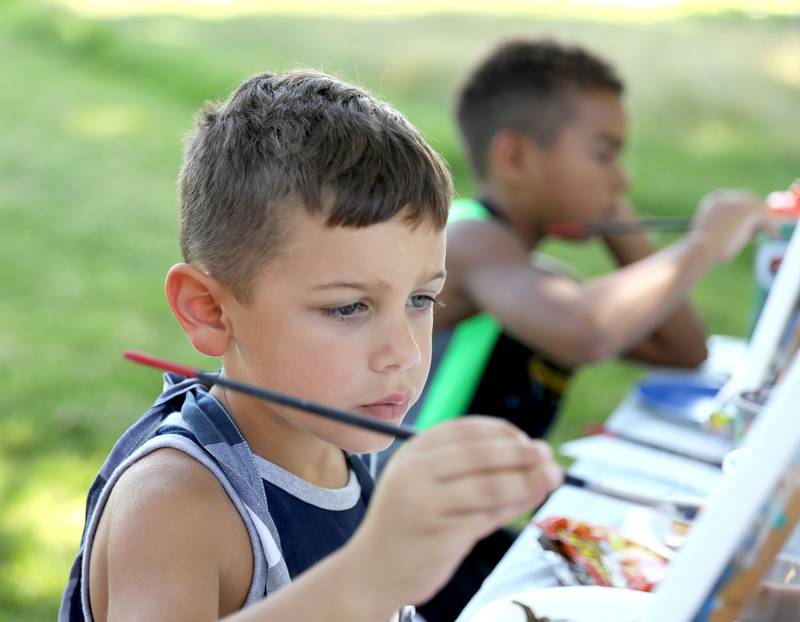 Jacob Valdez, 4, (left) and Moses McGhee, 7, work on their paintings of horses during a painting class with Chelsea McGhee Studios at the Little Cottage on the Farm in Kaneville on Thursday, July 27, 2023.