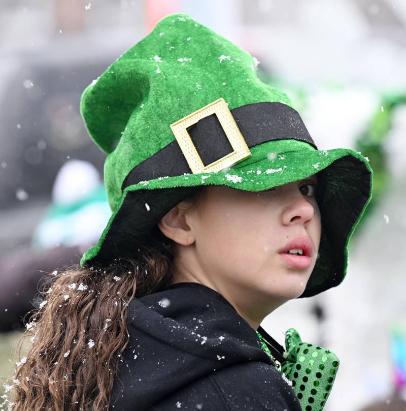 Ari Ballard, 13, of St. Charles shivers as snowflakes fall prior to the start of the St. Charles St. Patrick’s Parade on Saturday, March 14, 2026.
