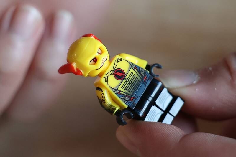 Ryan Linsner, co-owner of Bricks & Minifigs LEGO store in Crest Hill, holds a fake LEGO minifigure of Reverse-Flash. Hundreds of franchise themed knock offs are sold under the definition of “custom” or “building blocks”.