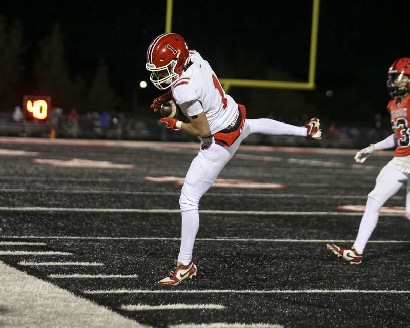 Yorkville's Colton Spychalski (1) brings in a catch on the sidelines during football game between Yorkville at Bolingbrook Friday, Oct 24, 2025 in Bolingbrook.