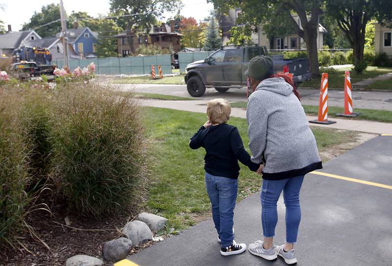 People look at the remains of homes in the 300 block of Lincoln Avenue on Tuesday, October 10, 2023, after an explosion following a gas leak in the area leveled one  home as caused several fires.