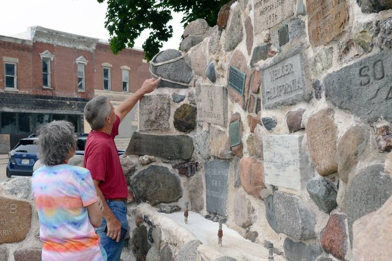 Chris Mann, of Rockford, (right) points to an inscription on the Veterans Memorial Fountain while his aunt, Judy McNett, of Oregon, watches on Thursday, Aug. 29, 2024, in downtown Mt. Morris. Mann's grandfather, Heathcote "Hec" Mann, designed the recently restored fountain, which was erected in 1926.