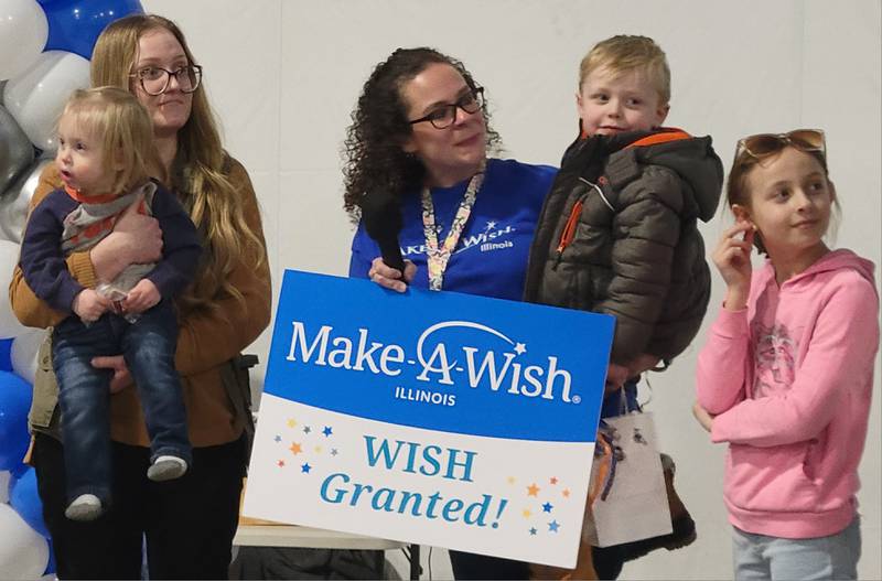 Four-year-old Lucas King (second from right) of Oglesby, shown in the arms of his wish coordinator Ashley Montgomery of Mendota (left), had his wish to go to Disney World in Florida granted at the 2025 Penguin Plunge Saturday, Jan. 25, 2025 at Skydive Chicago in Ottawa.