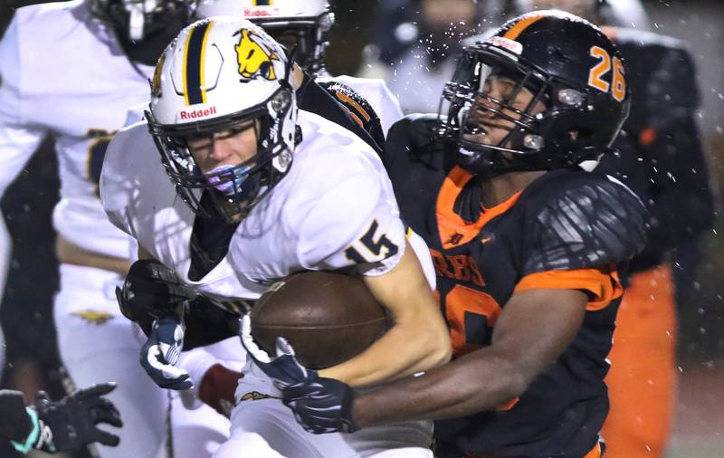 Neuqua Valley's Carter Stare is wrapped up by DeKalb's Jaleel Wallace during their game Friday, Oct.14, 2022, at DeKalb High School.
