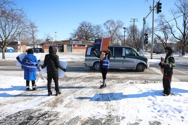 Residents holds signs along Richards Street for an Illinois Youth & Family Services anti violence rally on Monday, Jan. 26, 2026 in Joliet.