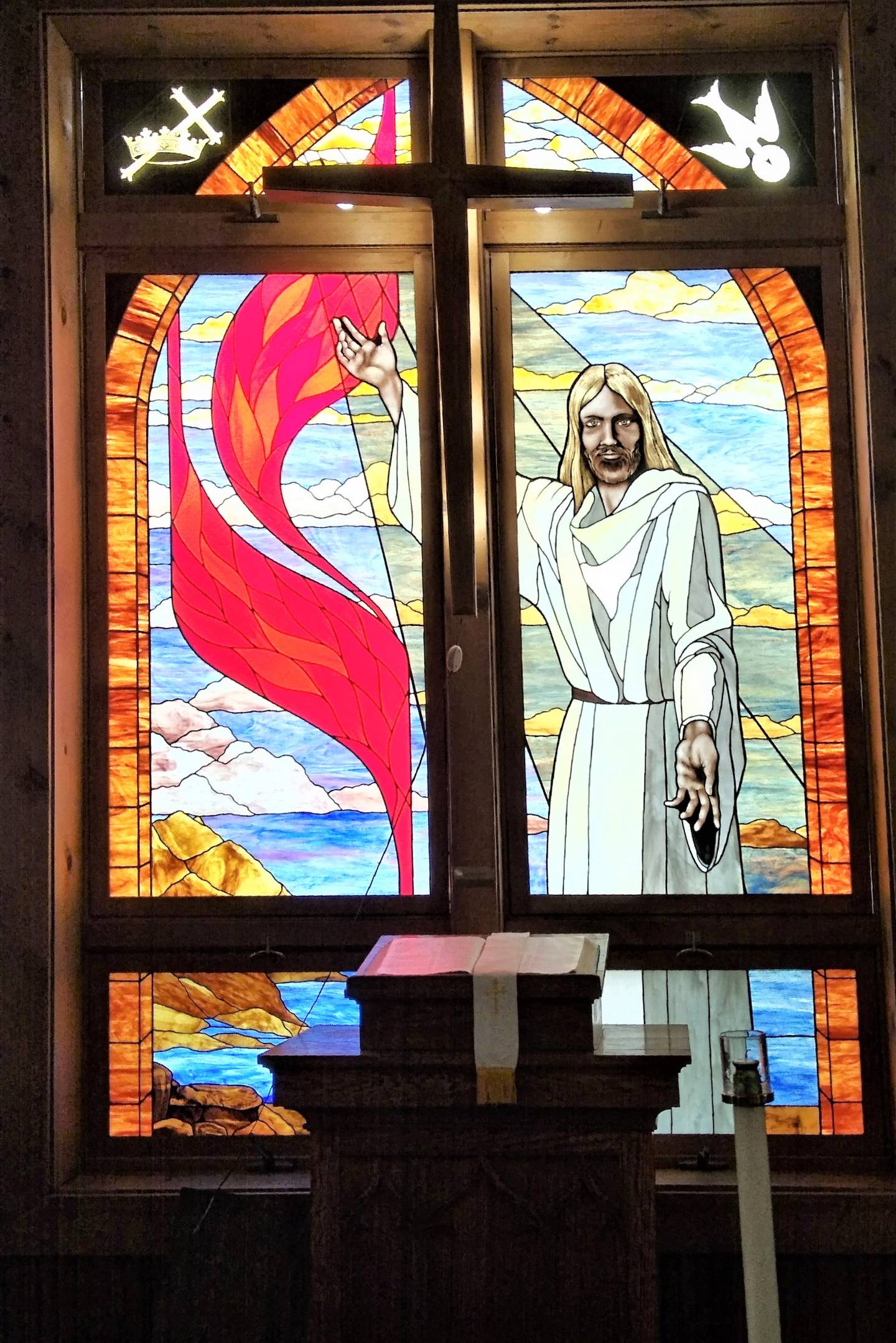 A stained glass window depicting Jesus is featured at the front of Cortland United Methodist Church.