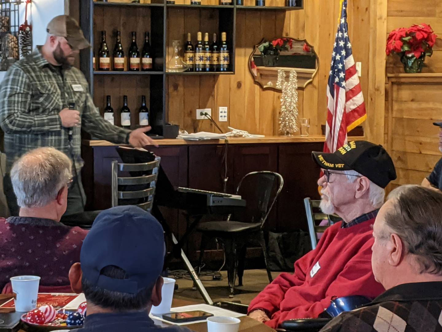 Michael Gilio, a former infantry unit leader for the U.S. Marine Corps from June 2003 to July 2011, speaks to those attending the Fox Valley Veterans Breakfast Club's holiday celebration at 113 Main restaurant in downtown Oswego on Thursday, Dec. 11, 2025.