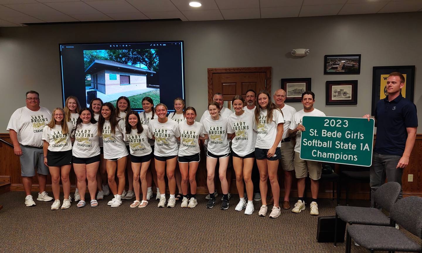 The state champion St. Bede softball team poses for a photo Wednesday, July 5, 2023, with a commemorative sign the city of Peru plans to hang at Washington Park. Another sign already was hung at McKinley Park.