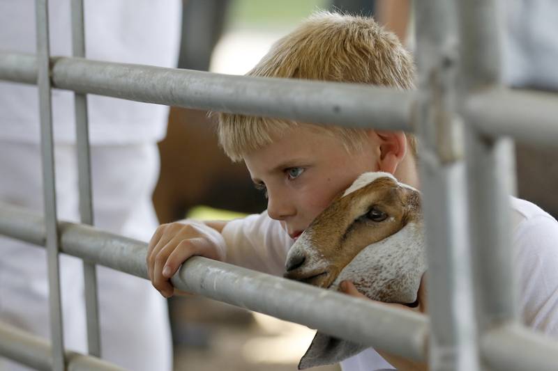 Kyler Kitson, with his goat Willow, wait for the 4-H Goat Showmanship Competition to start during the opening day of the McHenry County Fair on Tuesday, July 29, 2025.