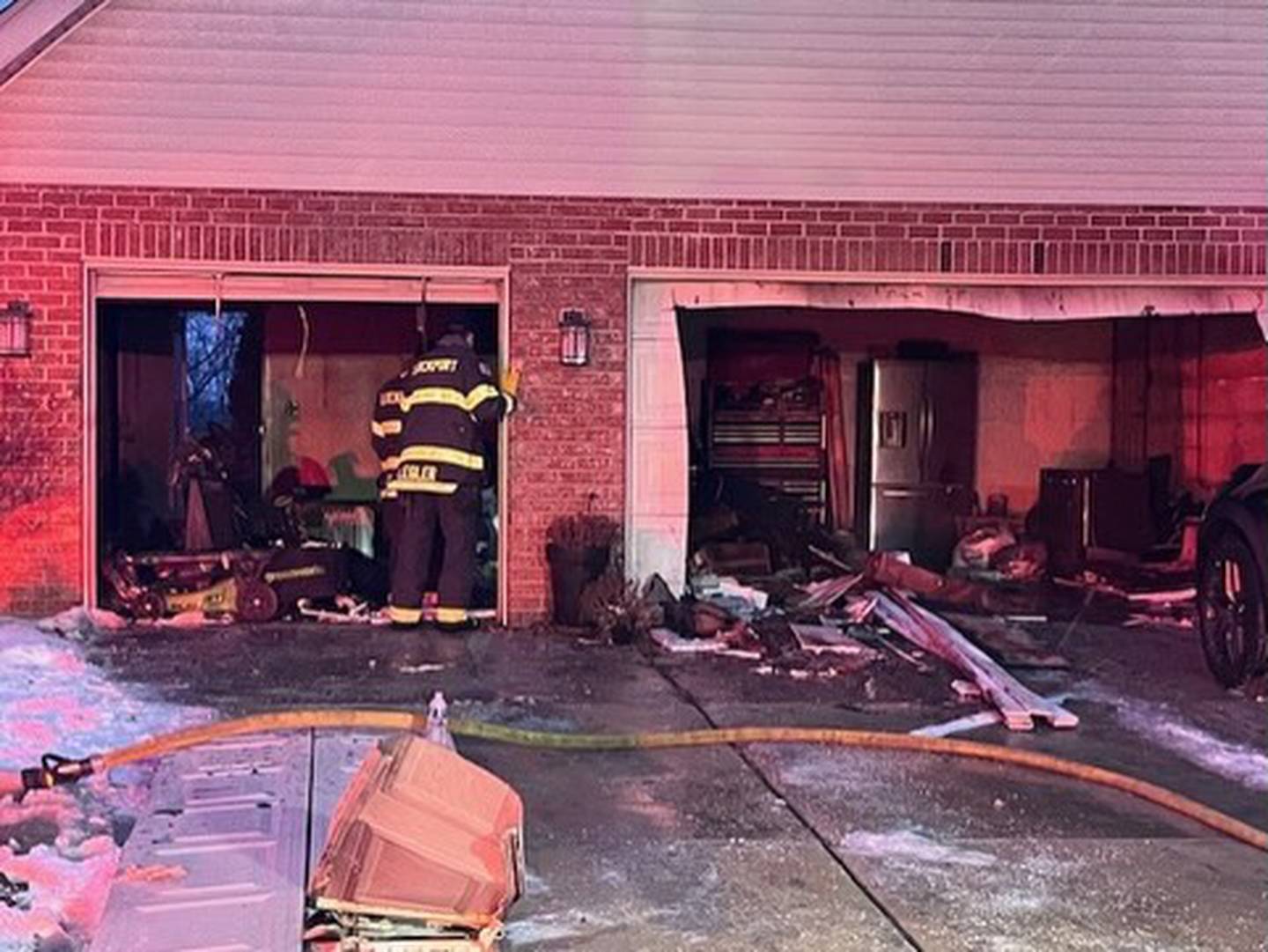 Firefighters examine a garage which caught fire in the early hours of Jan. 31 in the 16700 block of Swift Arrow Drive.