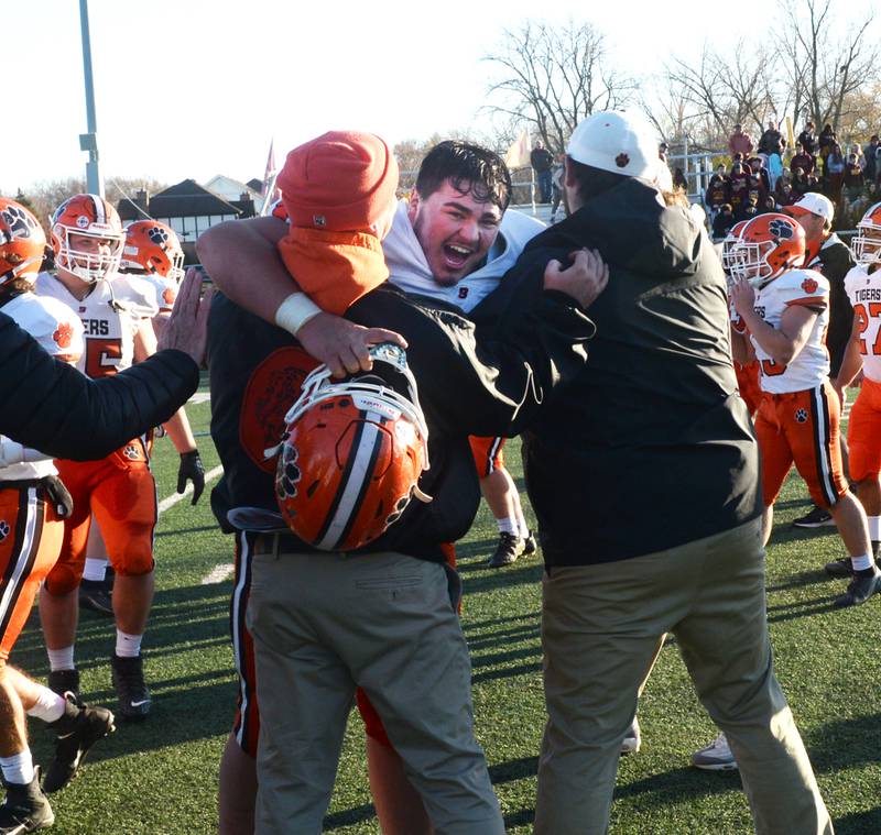 Byron's Nolan Brass (74) hugs his coaches after the Tigers' win over Lombard-Montini in 3A semifinal action in Lombard on Saturday, Nov. 18, 2023.