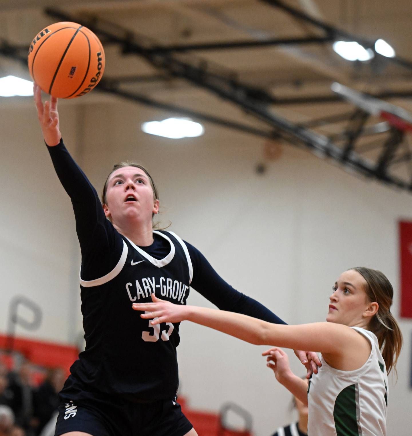 Cary-Grove’s Ellie Mjaanes, left, drives to the basket for a layup against Grayslake Central’s Katelyn Marcelain during the Class 3A North Chicago sectional final on Thursday, Feb. 27, 2025 in North Chicago.