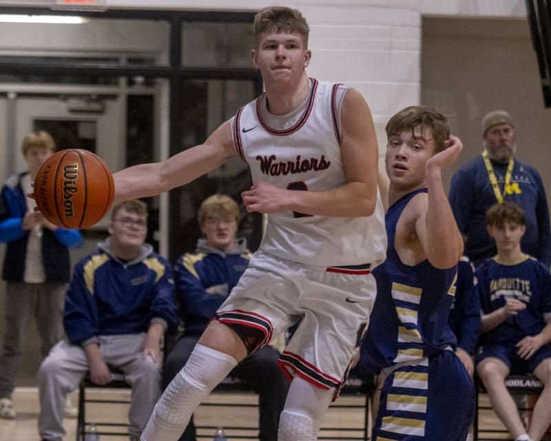 John Moore makes a cross court pass to a team mate while being pressured by Marquette during the varsity game at Woodland Highschool on January 30, 2024.