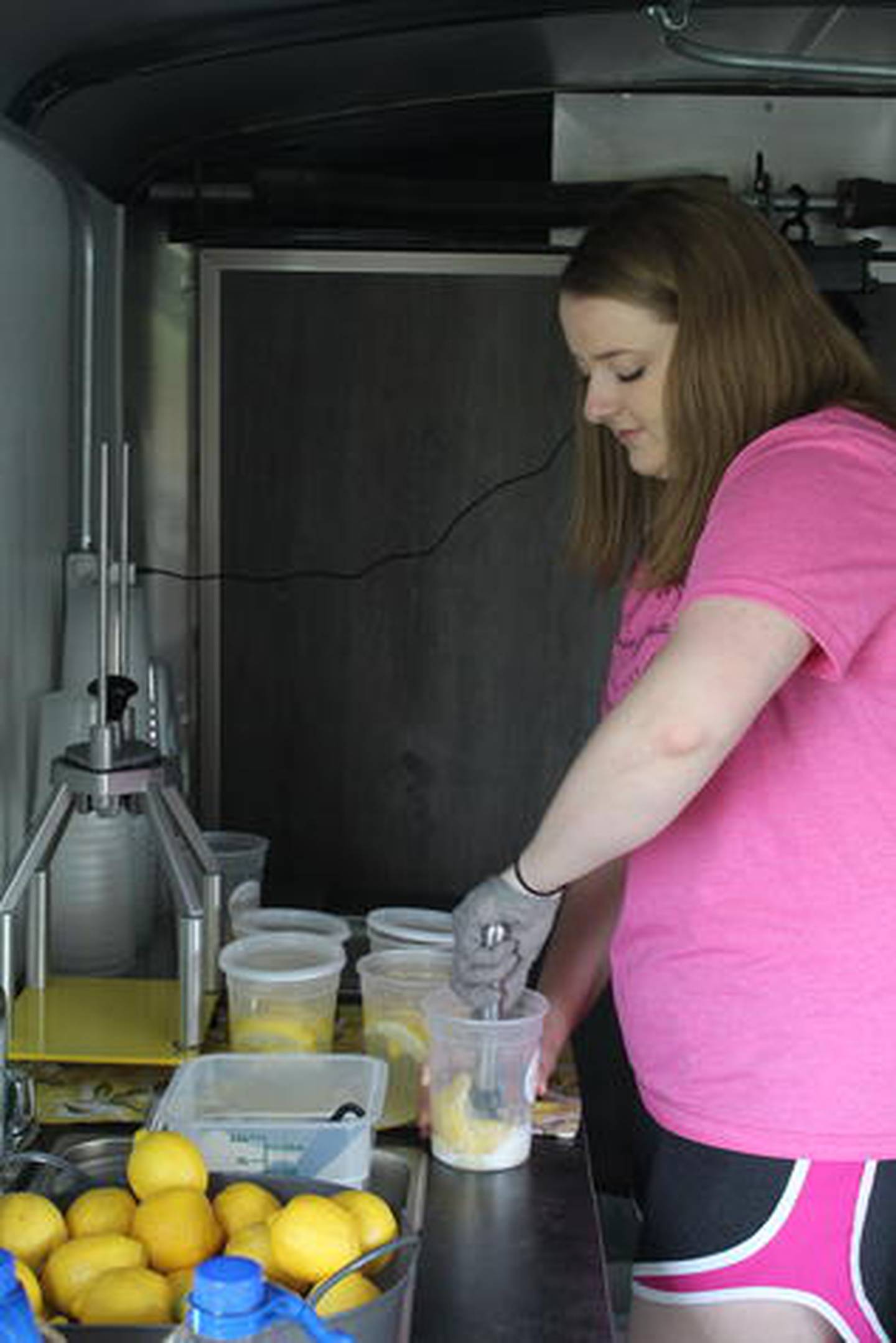 Main Squeeze owner Madison Wescott prepares a cup of lemonade for a customer. The cups are 32-ounces and parts of the lemons are left on the bottom for more flavor.