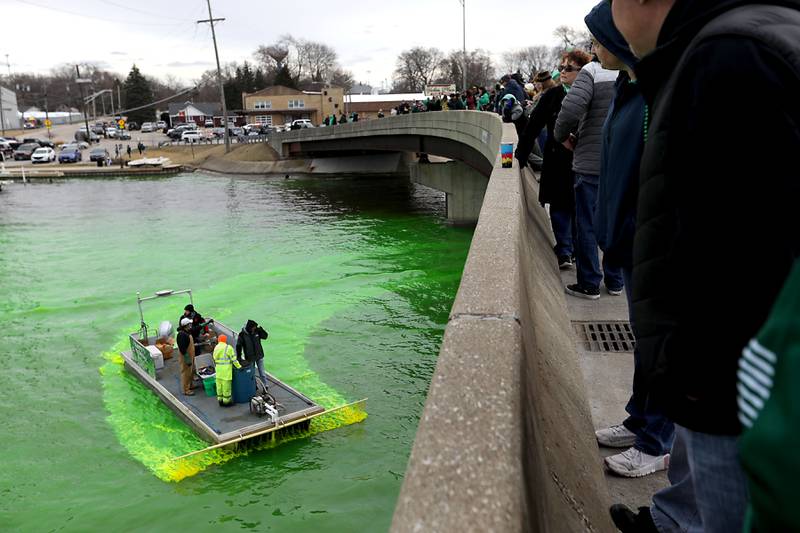 People watch from the bridge as dye is sprayed into the Fox River to dye the river green during the McHenry’s ShamROCKS the Fox Festival on Saturday, March 14, 2026, in McHenry.