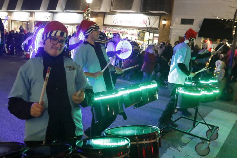 Members of the Crystal Lake Strikers Drumline entertain as they pass by during the annual Festival of Lights Parade on Friday, Nov. 26, 2021, in downtown Crystal Lake.