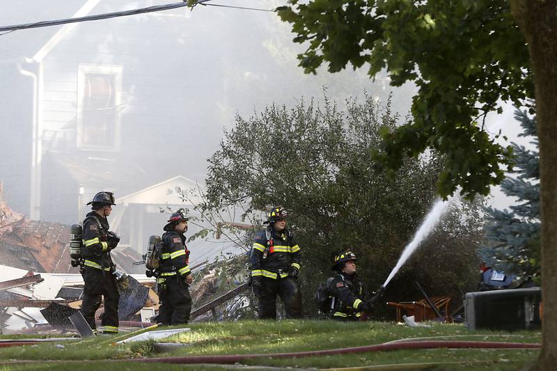 Firefighters battle a house fire in the 300 block of Lincoln Avenue in Woodstock Monday, Oct. 9, 2023, after an explosion following suspected gas leak in the area.