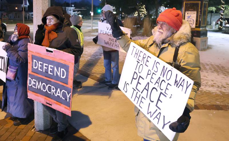 Members of Responsive Engagement Activating Civic Talent, along with or demonstrators hold their signs and wave at passing cars Friday, Jan. 6, 2023, during a Stand for Democracy demonstration at Memorial Park in downtown DeKalb. The second annual event was held to affirm the attendees commitment to American democracy.