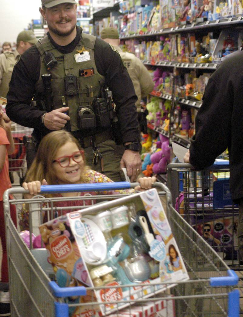 Lola Betts and Deputy Sean Coutts navigate around shoppers Saturday, Dec. 13, 2025, at Sterling Walmart.