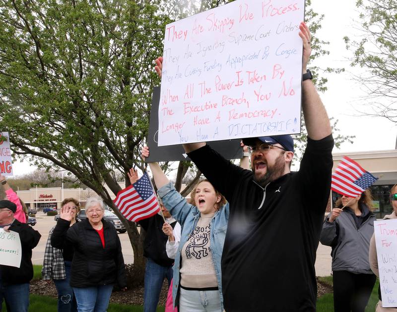 Protesters let their voices be heard as they march north on Sycamore Road Saturday, April 19, 2025, during a “No Kings” rally and march that started at Hopkins Park in DeKalb. The group was protesting what they’ve argued is the unlawful and harmful federal policies of President Donald Trump and his administration.
