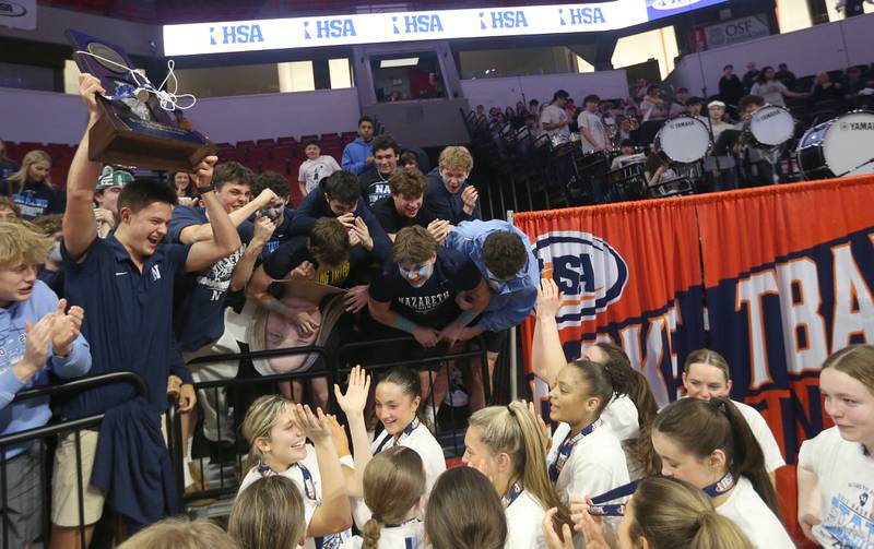 Nazareth students hoist the Class 4A State girls basketball championship trophy with the team watching on Saturday, March 7, 2026 at CEFCU Arena in Normal.