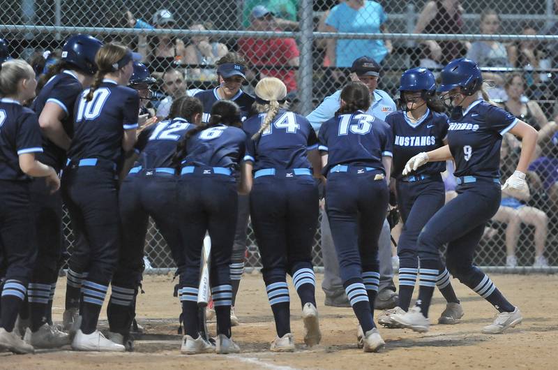Downers Grove South's Grace Taylor (9) is greeted by all of her teammates at home plate after hitting a home run during a game against Downers Grove North on May. 12, 2022 at McCollum Park in Downers Grove.