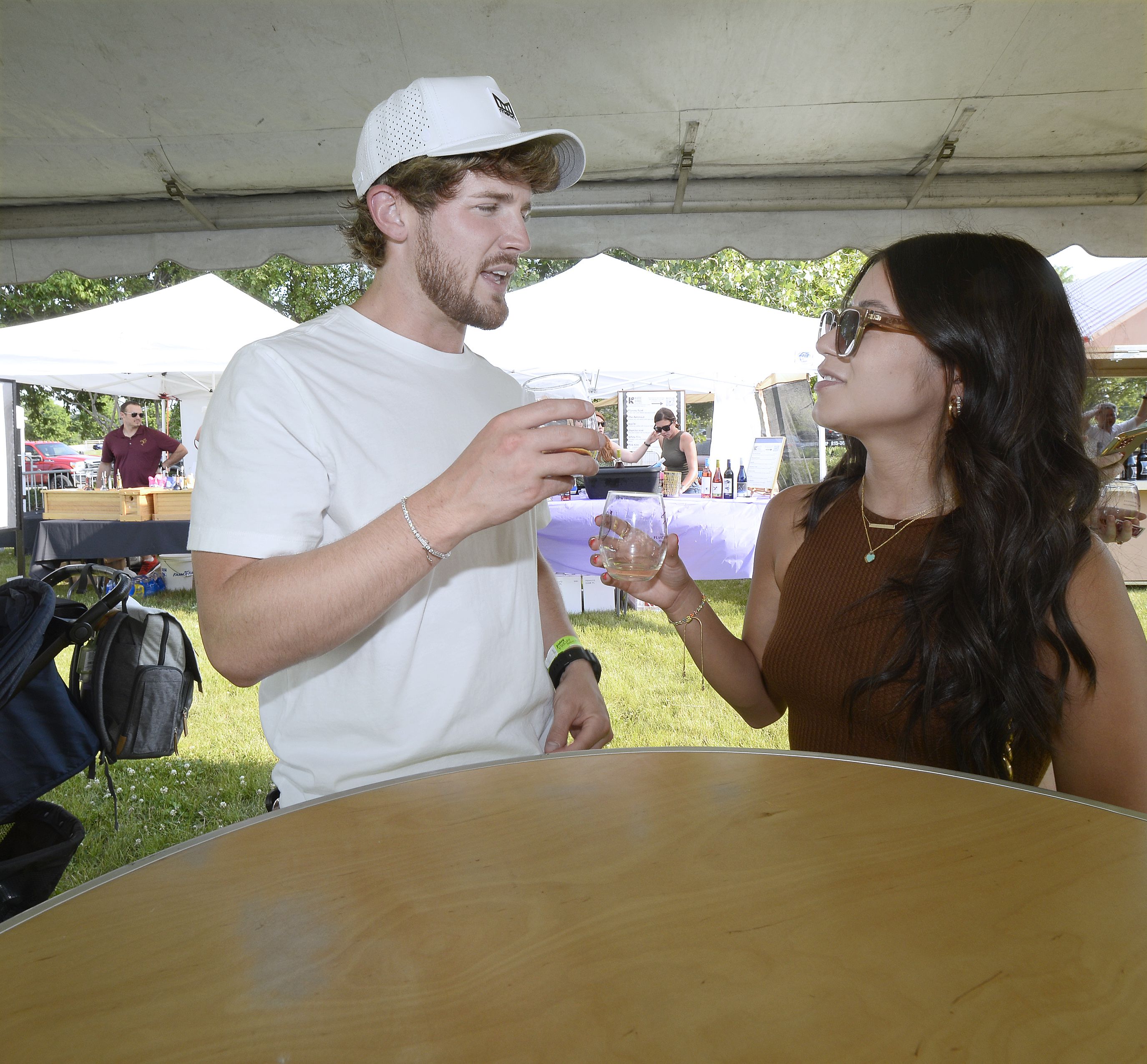 Kris Fredrickson and Mya Izaguirre enjoy a shady spot Saturday, June 2, 2023, on the Jordan block to sample their wine during opening night of the 2 Rivers Wine Fest in Ottawa.