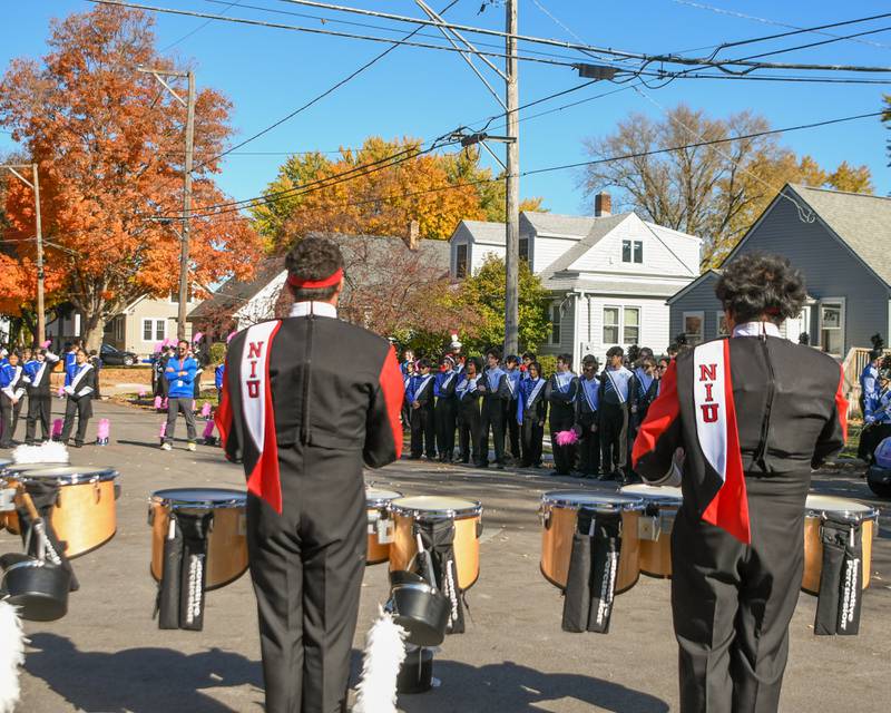 Northern Illinois University’s marching band drummers perform a routine while other local bands listen before the start of the Pumpkin Parade on Sunday Oct. 28, 2024, downtown at the 63rd annual Sycamore Pumpkin Festival.