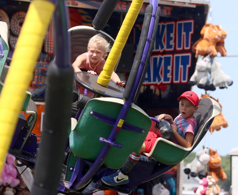 Addison Baiser, 7, of St. Louis takes a spin with her cousin Domenico Caraglia, 7, of Winthrop, Massachusetts on the Tornado ride during Fiesta Days at Petersen Park in McHenry Sunday. The kids were in town visiting their grandparents who live in McHenry.