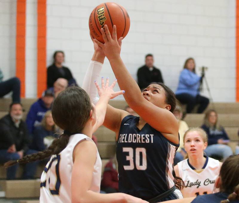 Fieldcrest's Aliah Celis runs past Marquette's Kaitlyn Davis to score a basket during the Integrated Seed Lady falcon Basketball Classic tournament on Monday, Nov. 13, 2023 at Flanagan High School.