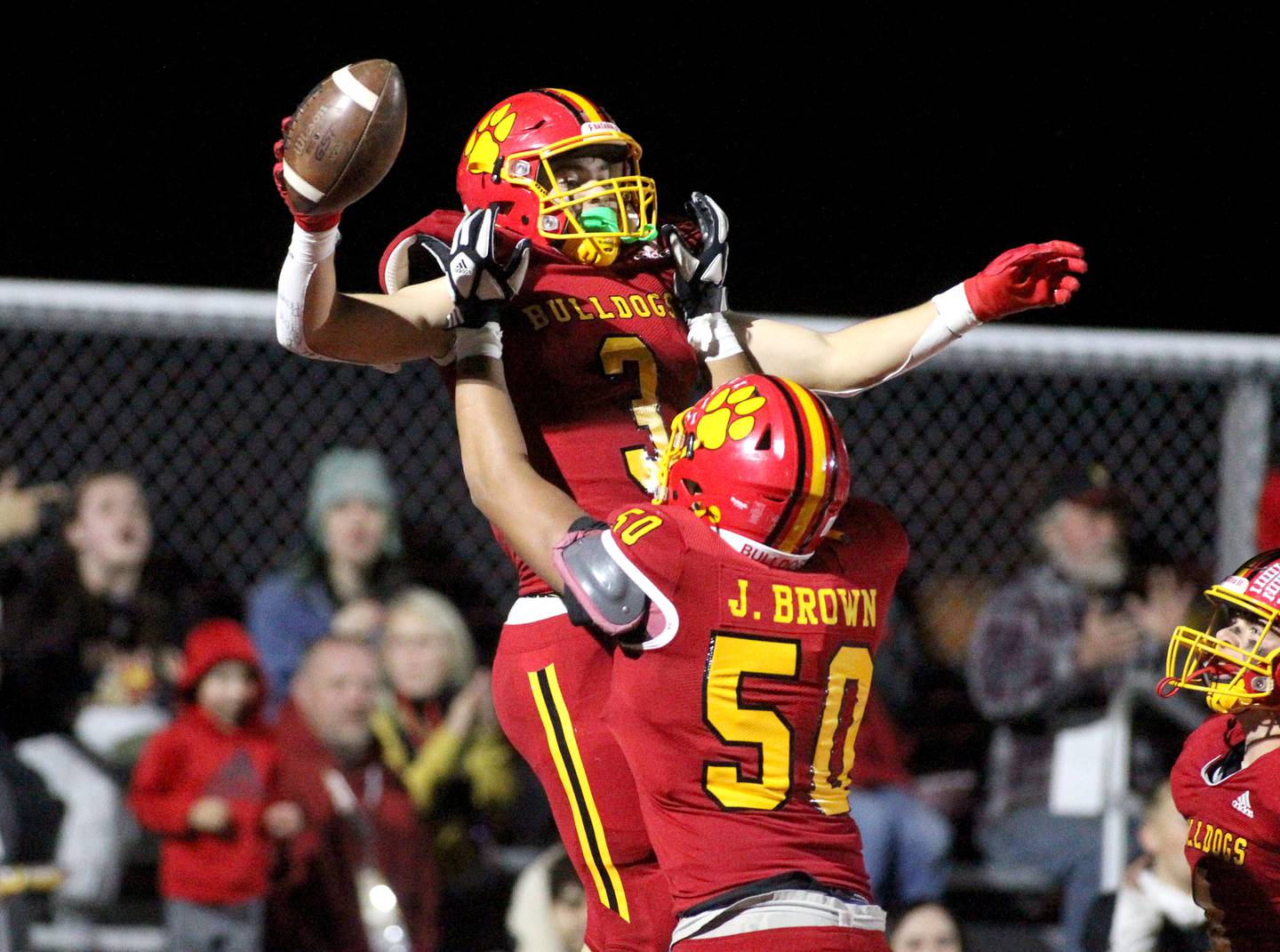 Batavia’s Jonathan Brown lifts teammate Ryan Whitwell following Whitwell’s touchdown in the second quarter during a game at Batavia on Friday, Oct. 21, 2022.