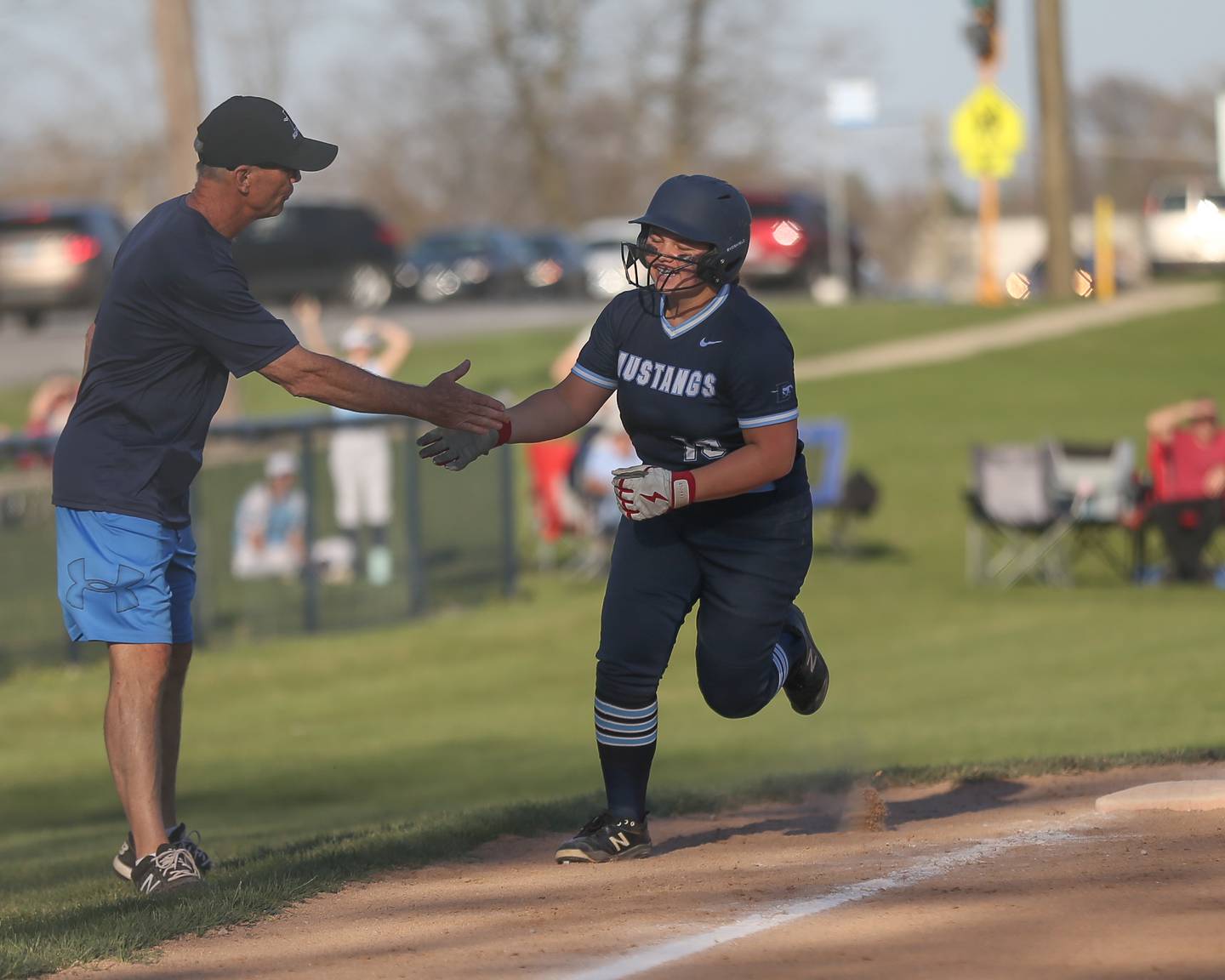 Downers Grove South's Miah Wanserski (10) is congratulated while rounding third after hitting a homerun during varsity softball game between St Charles East at Downers Grove South.  April 12, 2023.