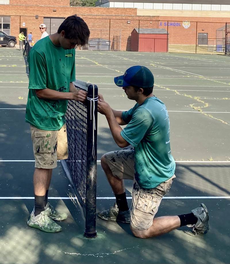 Employees of Midwest Sports remove the nets from the tennis courts at 53rd Street and Catherine Avenue in La Grange. The nets will soon be reinstalled as tennis courts closed more than a year will be repaired and again open for play. (Photo by Steve Metsch)