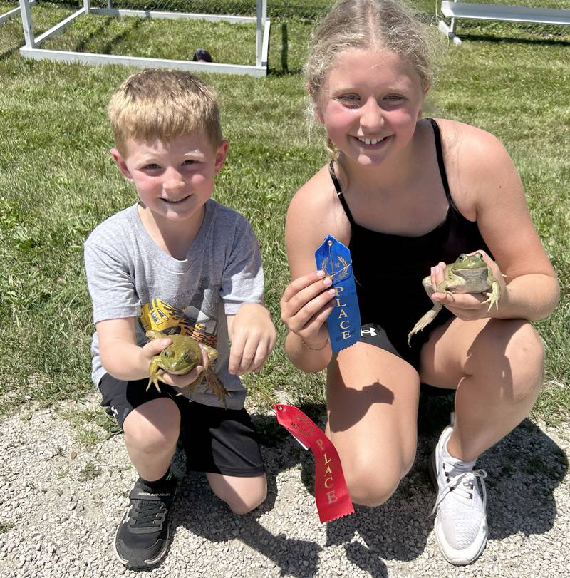 Georgia Walls, 9, and Nolan Sprecht, 6, of Hooppole, hold their frogs and the ribbons they won at the Hooppole Fun Day's Frog Race held Saturday, June 28, 2025 in Hooppole.