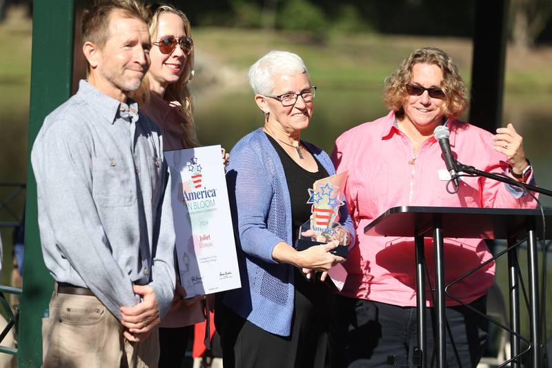 Arborist Jim Teiber, left to right, Joliet City Planner Jayne Bernhard and arborist Rita Renwick are presented with several awards by American in Bloom Executive Director Laura Kunkle at the rededication of the Gardens and Arbors along North 129th Infantry Drive on Tuesday, Oct. 8, 2024 in Joliet.