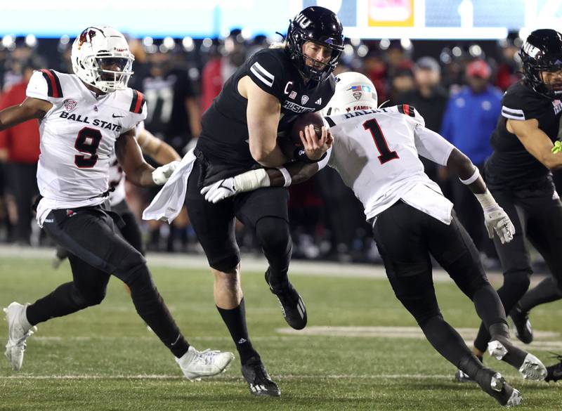 Northern Illinois' Rocky Lombardi breaks the tackle of Ball State's Aljareek Malry during their game Tuesday, Nov. 7, 2023, in Huskie Stadium at NIU in DeKalb.