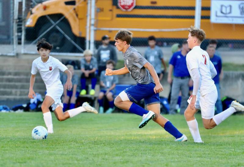 Princeton's Josh Orwig runs down the ball chased by L-P's Adrian Gonzalez (left) and Jason Curran at Bryant Field Thursday night. The Cavs won 7-0.