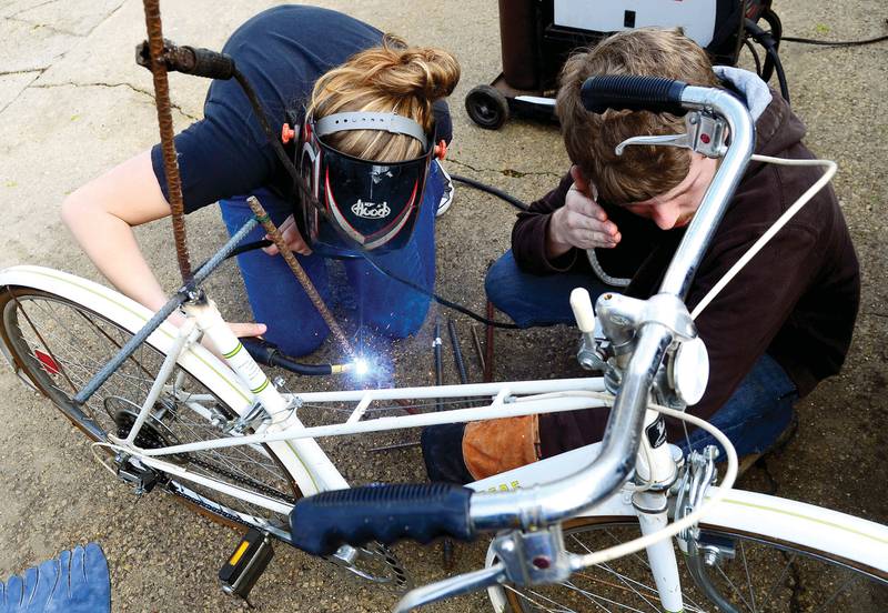 Sloane Wolfe (left) and Houston Sulouff work on a bike sculpture March 30, 2012 in Sterling. The two are welding the sculpture for Bud LeFevre who is displaying the bike on the streets of Dixon for the May Second Saturday celebration.