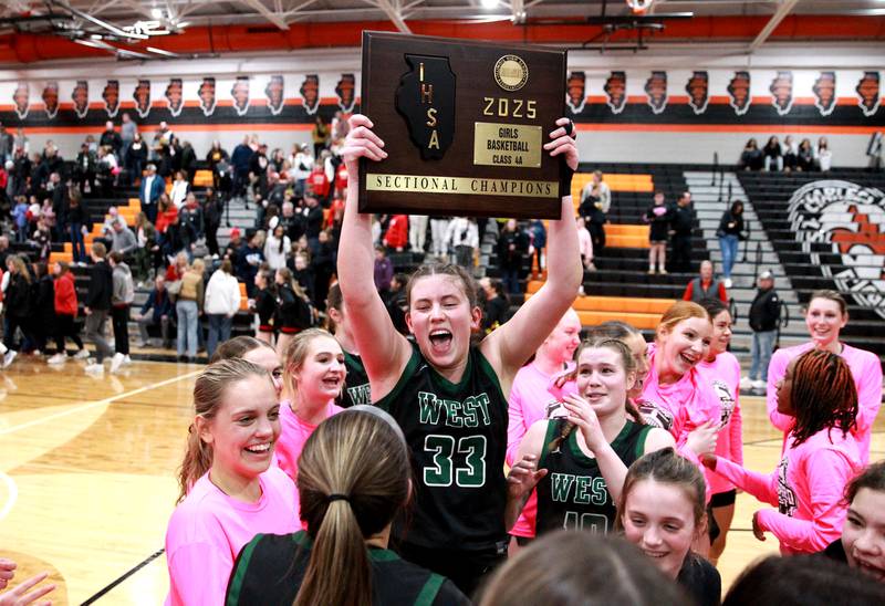 Glenbard West's Makenna Yeager holds up the team’s plaque following their Class 4A St. Charles East Sectional final over Batavia on Thursday, Feb. 27, 2025 in St. Charles.