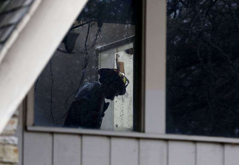 A Woodstock firefighter searches for a resident's items inside an apartment building Wednesday, Nov. 13, 2024, in the 700 block of St. John’s Road in Woodstock. The fire left one man dead, two in the hospital and more than 30 residents displaced, according to a Woodstock Fire/Rescue District spokesman.
