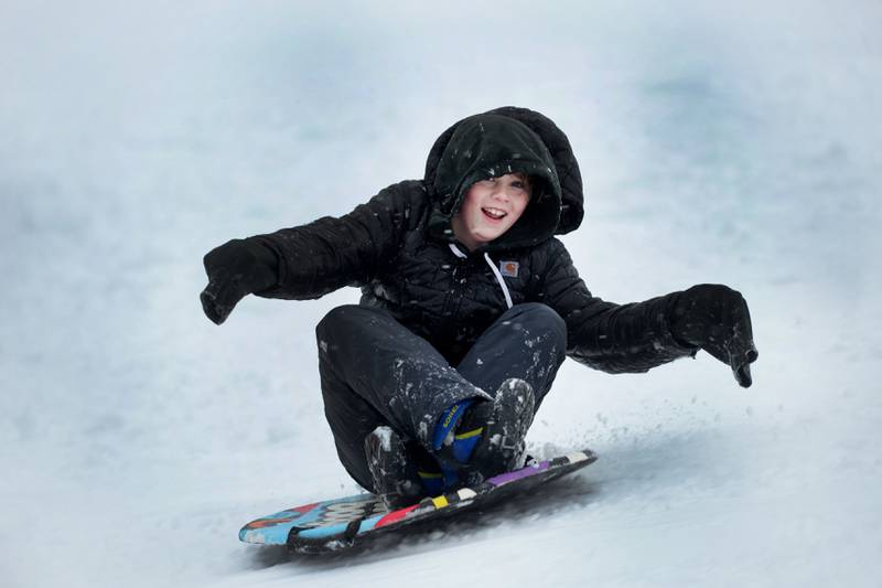 Luke Mason, 10, of Oregon, hits a bump as he rides his saucer sled down the sledding hill at Oregon Park West on Friday, Jan. 12, 2024  Friday's snowstorm brought more than 6 inches of snow to Ogle County by late afternoon creating difficult driving conditions for motorists, but plenty of fun for kids.