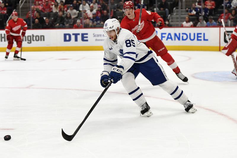 Toronto Maple Leafs center Semyon Der-Arguchintsev, front, reaches for the puck during the first period of the team's NHL preseason hockey game against the Detroit Red Wings, Friday, Oct. 7, 2022, in Detroit. (AP Photo/Jose Juarez)