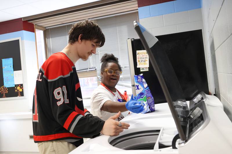 Kankakee School District students Precious Selvie, right, and Dakota Woodall practice starting a load of laundry at Kankakee School District's Avis Huff Student Support Services Center on Thursday, Nov. 13, 2025.