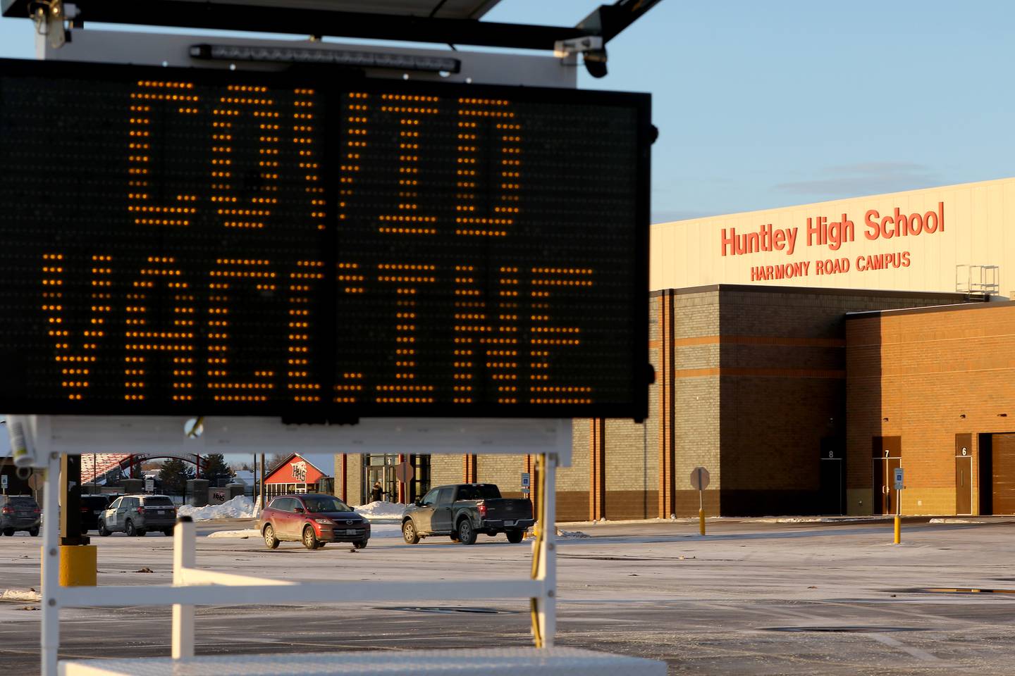 A sign outside of Huntley High School directs traffic to the COVID-19 vaccination entrance during a clinic for staff with Huntley School District 158 on Thursday, Feb. 11, 2021 in Huntley.  The clinic is targeting 48 staff member vaccinations every 15 minutes over the span of two days, with 1,717 vaccinations scheduled on Thursday and 1,793 on Friday.