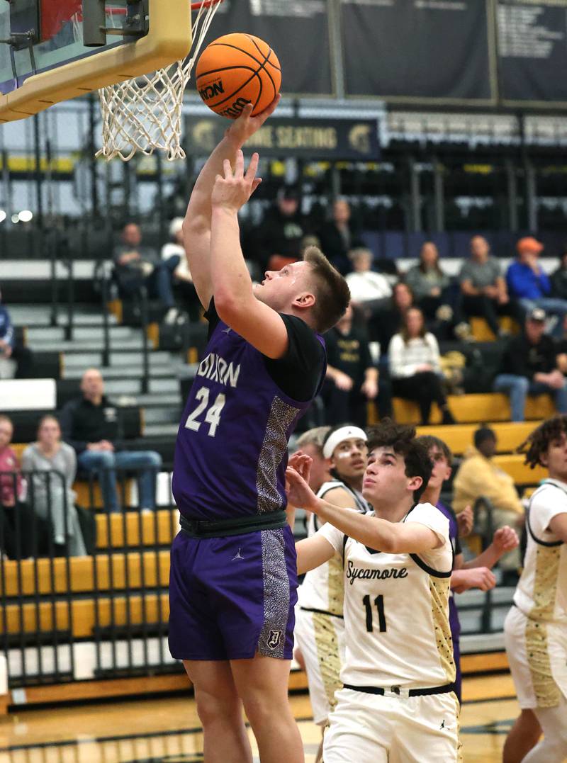 Dixon’s Eli Davidson gets a layup in front of Sycamore's Jake Shipley during their game Tuesday, Jan. 14, 2025, at Sycamore High School.