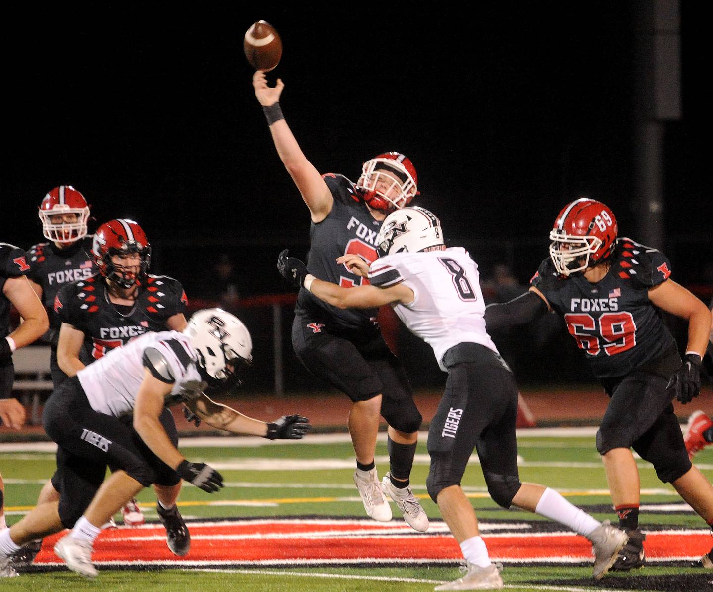 Yorkville quarterback Michael Dopart (9) takes a hit from Plainfield North defender Ryan Pass during a varsity football game at Yorkville High School on Friday, Oct. 20, 2023.
