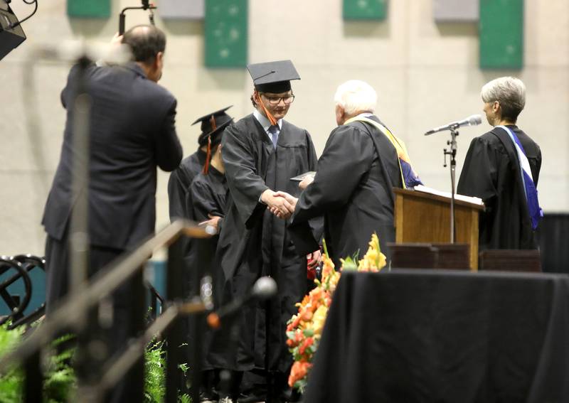 Ethan Szafranski crosses the stage during the Wheaton Warrenville South commencement ceremony on Saturday, May 24, 2025 at the College of DuPage in Glen Ellyn.