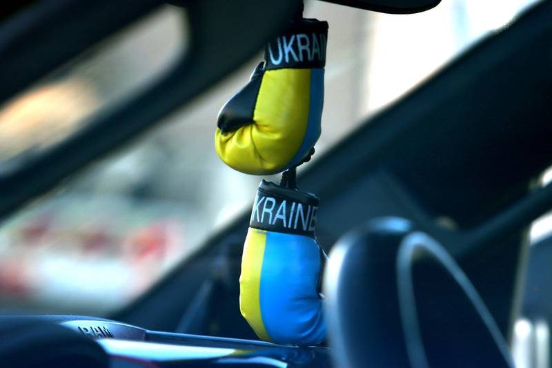A miniature pair of Ukraine-decorated boxing gloves dangle from a rear-view mirror. Drivers gathered Saturday morning in East Dundee for the Deblockade Mariupol truck protest rally hosted by Help Ukraine Foundation LTD to bring attention to the blockade of Mariupol.