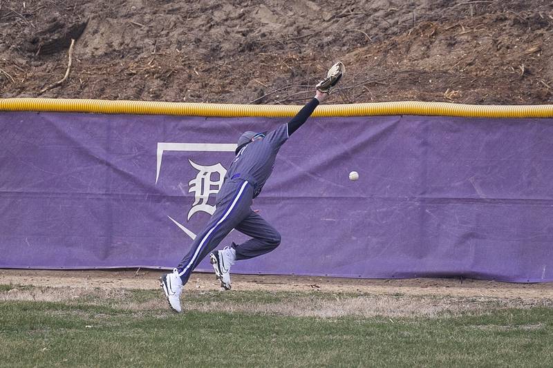 Dixon’s Eli Kirchoff reaches but can’t haul in a long fly ball against DeKalb Friday, March 21, 2025.
